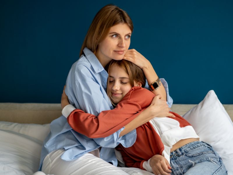 Caring mom embracing upset daughter